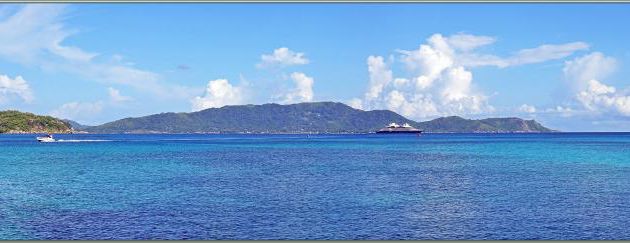 Le Bellot est ancré dans la baie Sainte-Anne, à gauche l'île Ronde, en arrière-plan l'île de La Digue (côte ouest) - Praslin - Seychelles