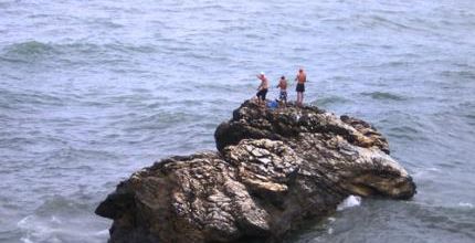 Trois pécheurs sur un rocher