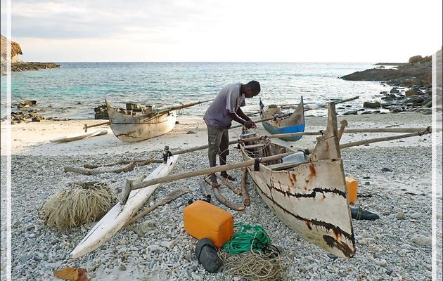 La marée monte, la nuit va tomber rapidement, il faut rentrer en traversant les rochers, sur la plage, un pêcheur se prépare pour aller poser ses filets - Tsarabanjina - Mitsio - Madagascar