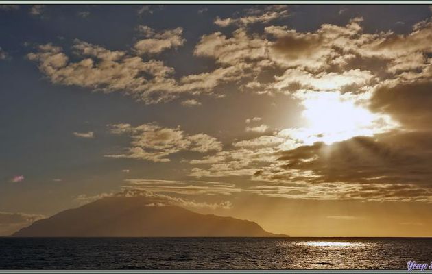 Le Lyrial navigue vers l'île Tristan da Cunha. Le sommet, The Queen Mary's Peak avec les lèvres du cratère du volcan, émerge des nuages 