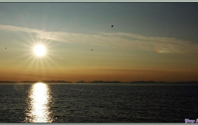 Soleil de presque minuit avec un photométéore rare : un nuage iridescent - Mer de Baffin - Nunavut - Canada