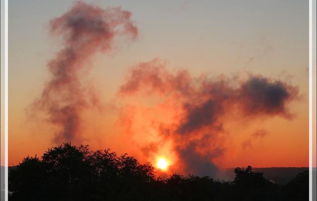 29 mars 2019 : au lever du soleil, la savane est en feu ! En réalité, ce sont les nuages formés par les chutes Victoria vues de notre hôtel - Victoria Falls - Zimbabwe