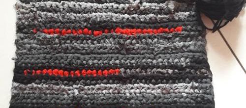 Un tapis en traphilo crocheté gris et rouge