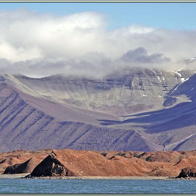 Île Coraholmen et ses terres voisines du Spitzberg : au nord-ouest le Kolosseum, (Colisée), en arrière plan de l'île, à l'est du fjord, le massif Kapitol (Capitole) - Fjord Ekmanfjorden - Svalbard - Norvège