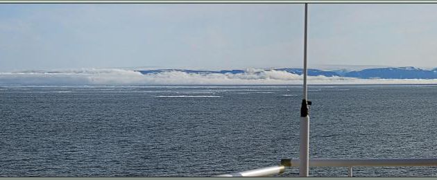 Le nord de la mer de Baffin est barrée par une épaisse brume rasante, les côtes du Nunavut et du Groenland avec de la banquise se profilent à l'horizon